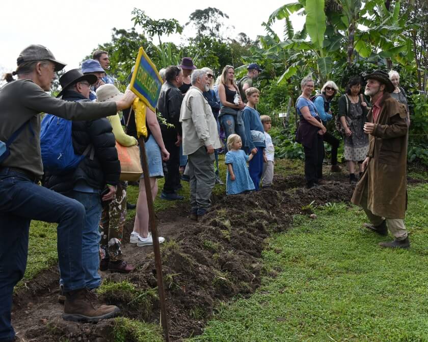 People gathered around and learning from the guy with a coat